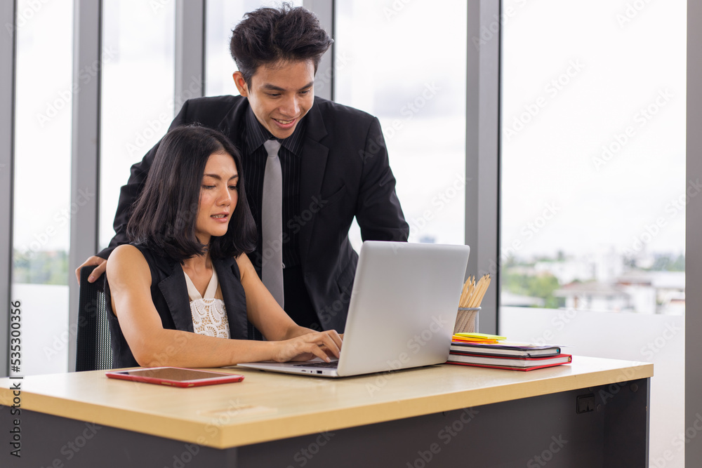 Two business people working together with smile on face using laptop at the office Two business people working together with smile on face using laptop at the office
