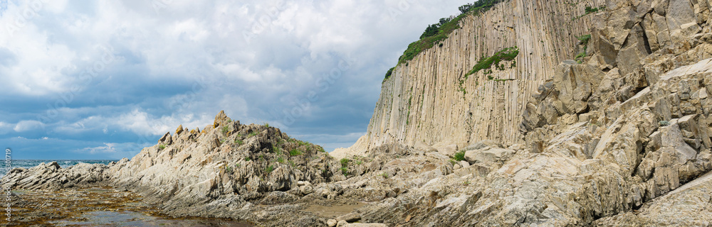 panorama with coastal cliff formed by solidified lava stone columns, Cape Stolbchaty on Kunashir island