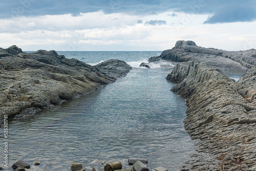 coastal seascape with beautiful columnar basalt rocks at low tide photo