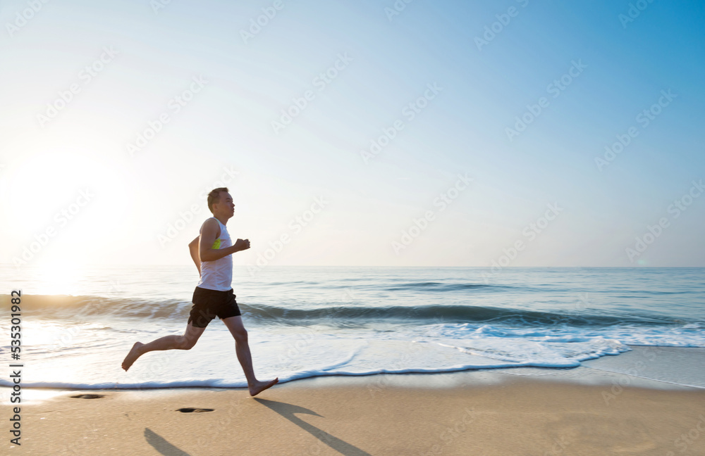 Young man running along beach in the morning Young man running along beach in the morning