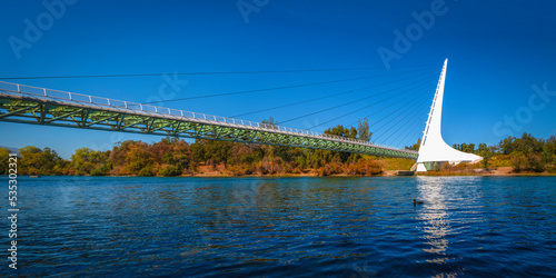 Panoramic autumn landscape at Sacramento River and wildlife animal sanctuary with the view of Sundial Bridge in Redding, Northern California photo
