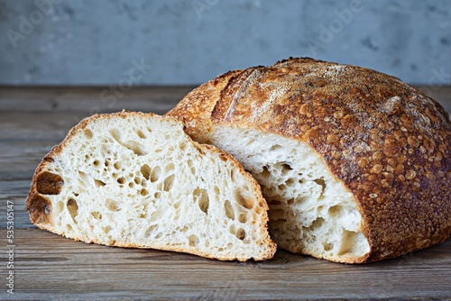 Fresh homemade sourdough bread with whole grain flour on a gray-blue background. Healthy food. photo