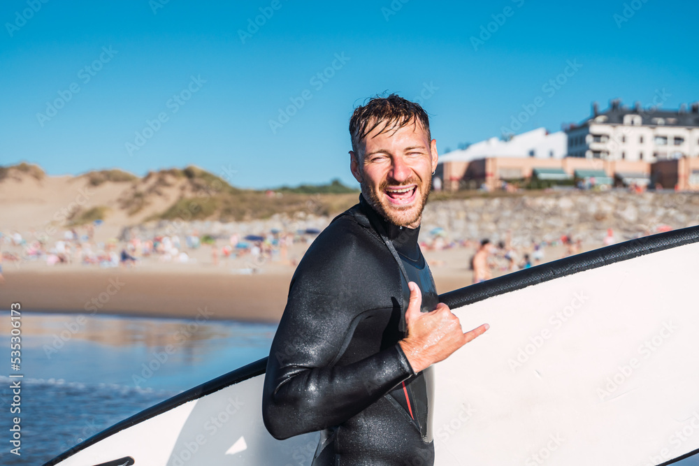 Happy man makes the surfer greeting of good times lived in the waves.