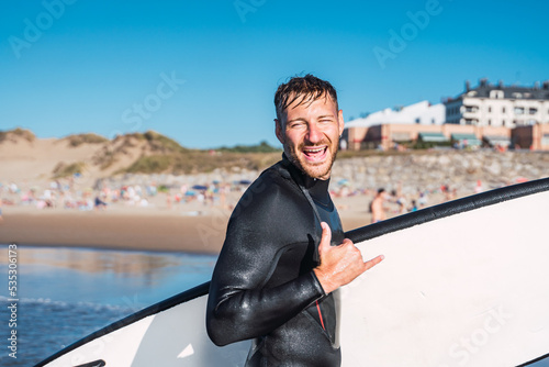 Happy man makes the surfer greeting of good times lived in the waves.