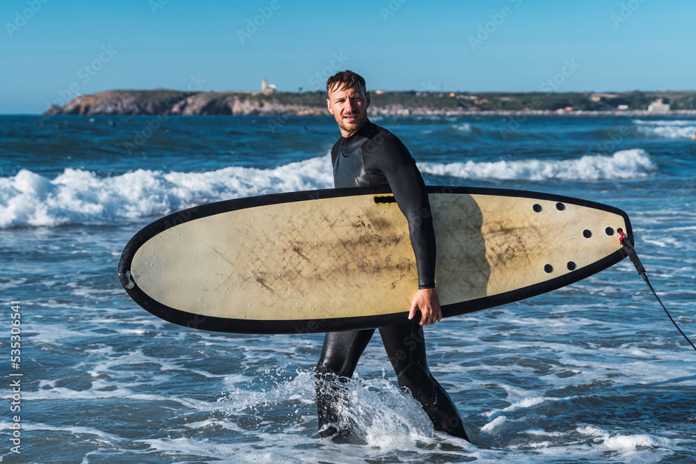 Man entering the sea with his surfboard