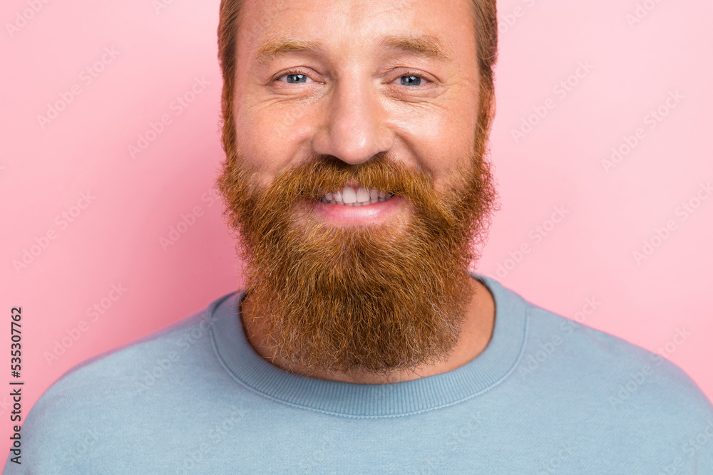 Close up photo of positive cheerful good mood man ginger beard dressed blue sweater smile at camera isolated on pink color background Close up photo of positive cheerful good mood man ginger beard dressed blue sweater smile at camera isolated on pink color background
