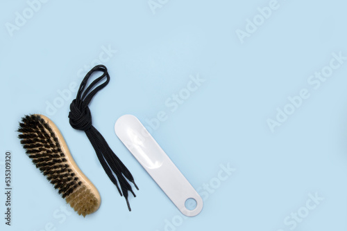 shoelaces  horn and brush for shoes on a blue background with copy space