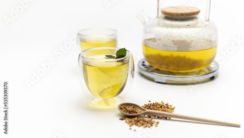 Buckwheat tea, Ku Qiao, in glass cups and teapot on white background, place for text, banner