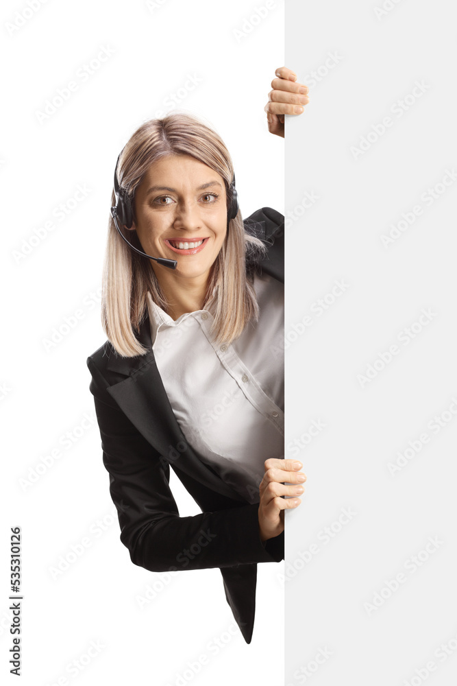 Female dispatch worker with a headset standing behind a blank white panel Female dispatch worker with a headset standing behind a blank white panel