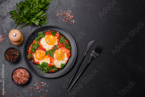 Shakshuka, a dish with fried eggs with tomato sauce, sweet pepper, garlic, onions, spices and herbs