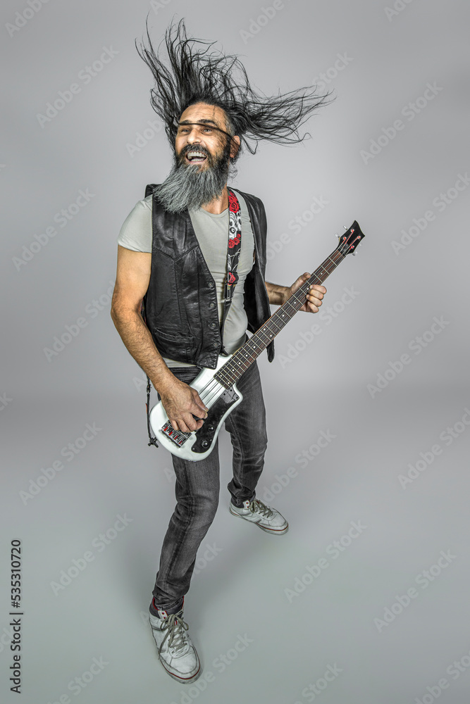 man with long fluttering hair plays bass guitar