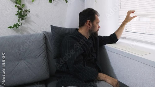 a middle-aged man in depression looks out the window