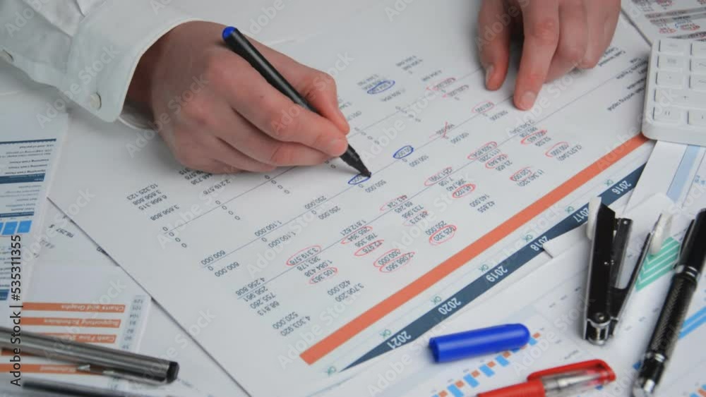 Close-up shot of a chartered accountant checking company balance sheet Close-up shot of a chartered accountant checking company balance sheet