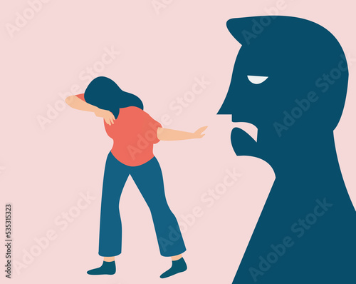 Scared woman victim of bullying concept. Shadow of a person blaming and yelling at a female covering her face. Stop verbal abuse against children and women. Say no to domestic violence prevention. photo