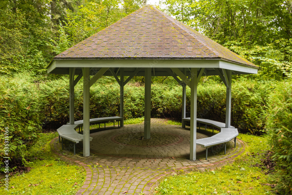 A gray canopy with a paved base in a green forest A gray canopy with a paved base in a green forest