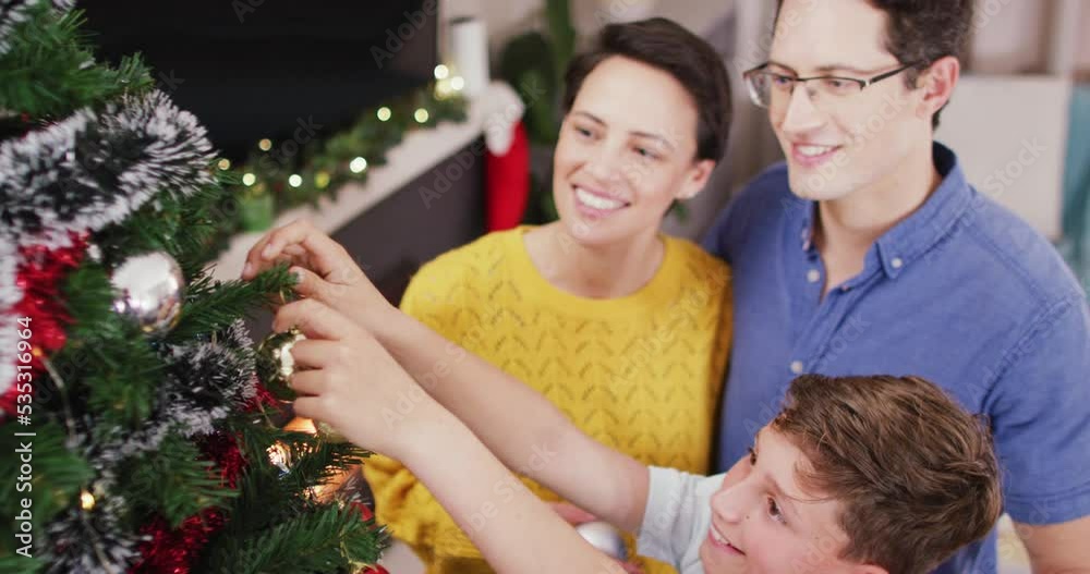 Happy caucasian parents and son decorating christmas tree at christmas Happy caucasian parents and son decorating christmas tree at christmas
