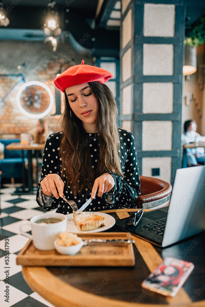 beautiful girl in a red beret eats a business lunch beautiful girl in a red beret eats a business lunch