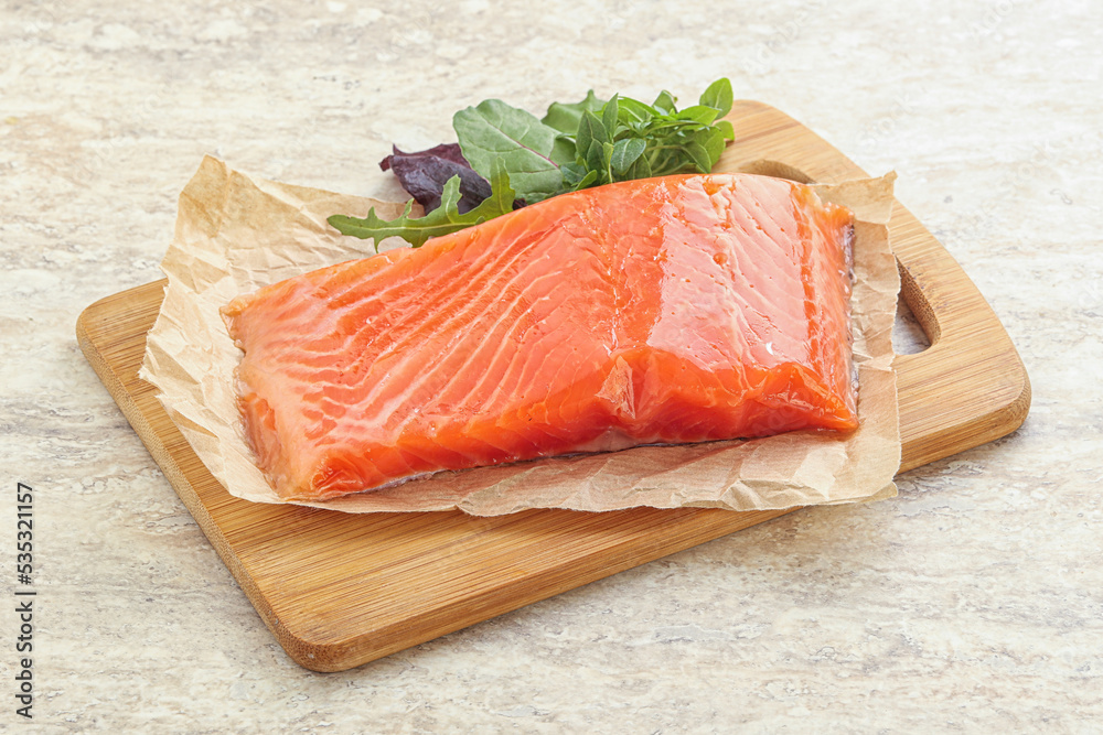 Raw salmon fillet over board