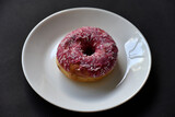 Delicious sweet donuts on a white plate. Donuts in glaze with filling close-up.