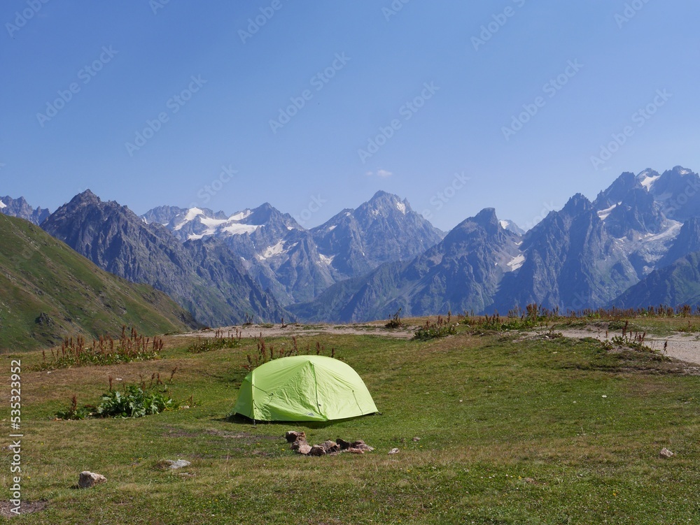 Camping tent at the Koruldi lakes, beautiful view of Great Caucasus mountains close to Mestia in Upper Svaneti, Georgia.