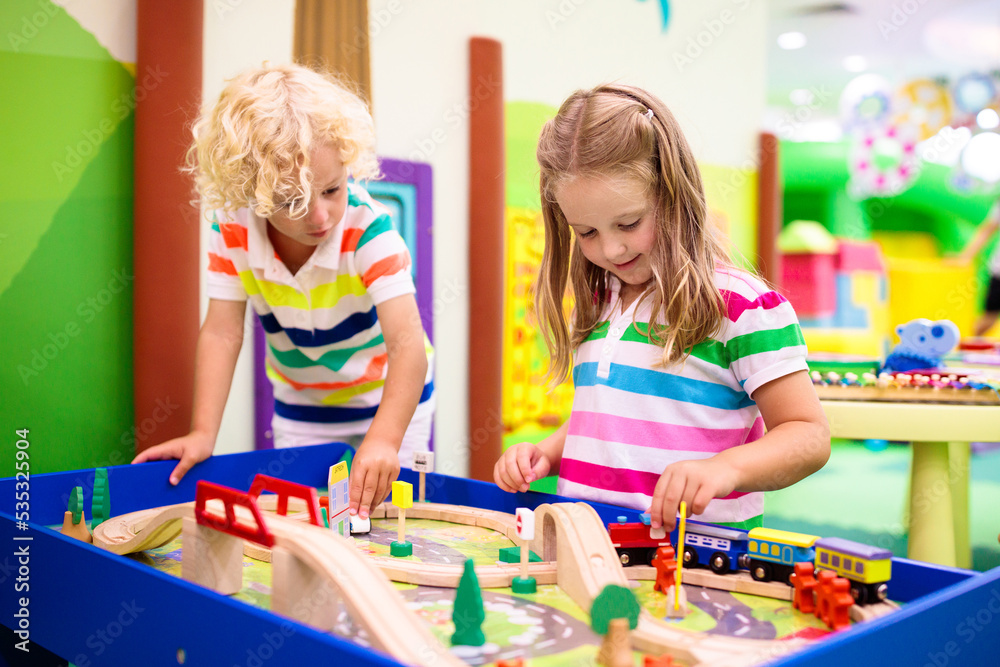 Fototapeta premium Kids play wooden railroad. Child with toy train.
