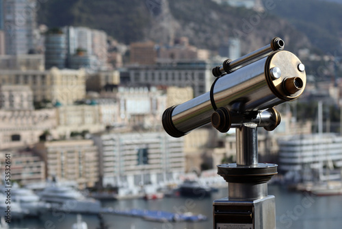 Monaco, Monaco - 02.10.2022: Morning view of the Principality of Monaco from the Prince's palace, with a telescope in the foreground, partly out of focus
