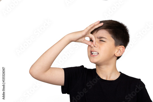 Little caucasian  kid wearing casual clothes smelling something stinky and disgusting, intolerable smell, holding breath with fingers on nose. Bad smell. Isolated on the white background