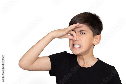 Little caucasian  kid wearing casual clothes smelling something stinky and disgusting, intolerable smell, holding breath with fingers on nose. Bad smell. Isolated on the white background