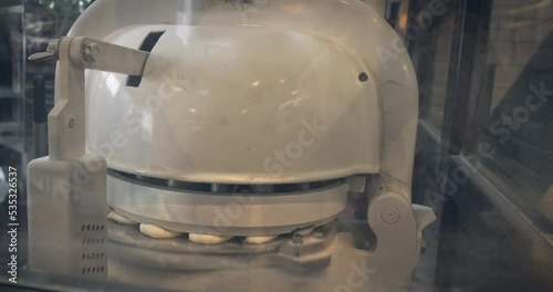 Making buns food bakery equipments at cafe, restaurant. Dough divider rounder automatic make pitta bread, closeup. Machine equal pieces automatically. Automate kneading dough motion, baking pieces 