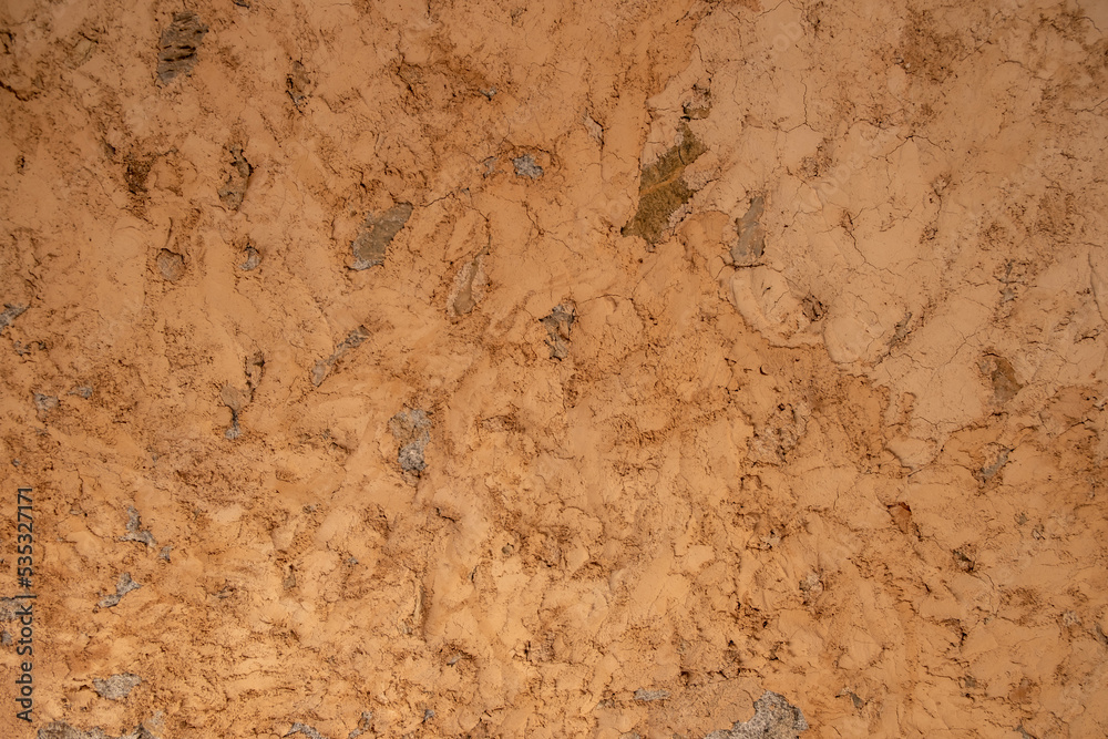 Mud plaster wall background texture. Dry brown empty soil ground, floor structure. Copy space.