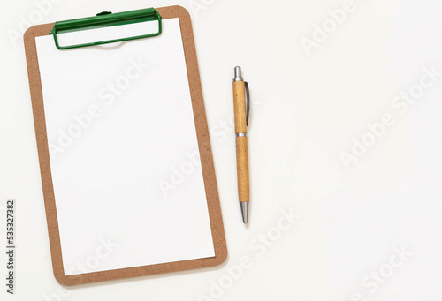 Wooden clipboard with empty paper and wood cover pen isolated cutout on white background. Space