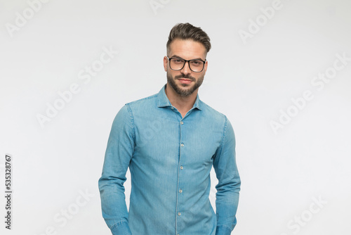 casual man standing against gray background and wearing eyeglasses © Viorel Sima