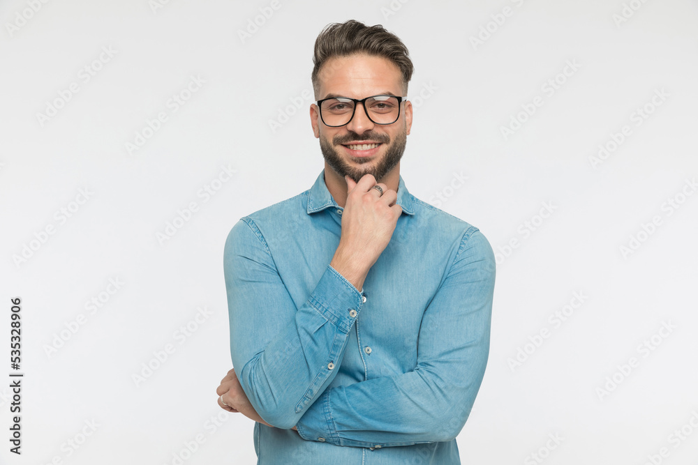casual man scratching beard and giving a big smile casual man scratching beard and giving a big smile
