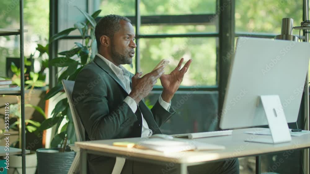 Shot of handsome african american businessman in a suit making business calls or records audio in the office feeling happy, smiling. Sunlight. Conversation. Slow motion