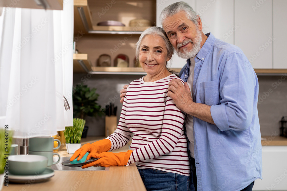 Fototapeta premium Senior Husband And Wife Washing Dishes In Kitchen And Smiling At Camera