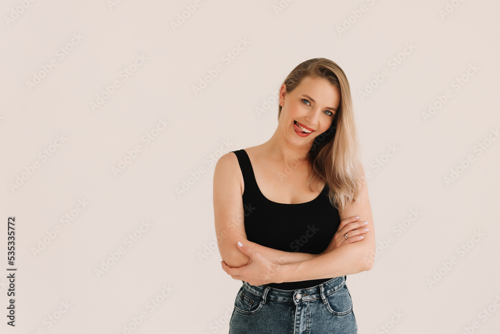 Portrait of a happy confident adult blonde business woman with positive emotions in a casual black T-shirt smiling and looking at the camera on a white isolated background. Space for text. Portrait of a happy confident adult blonde business woman with positive emotions in a casual black T-shirt smiling and looking at the camera on a white isolated background. Space for text.