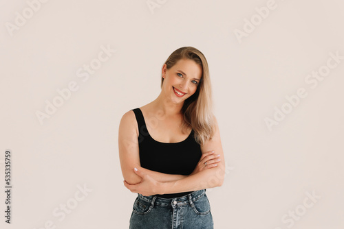 Portrait of a happy confident adult blonde business woman with positive emotions in a casual black T-shirt smiling and looking at the camera on a white isolated background. Space for text.