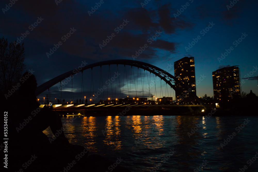 city harbor bridge at night.  Illumination, cloudy sky and calm lake