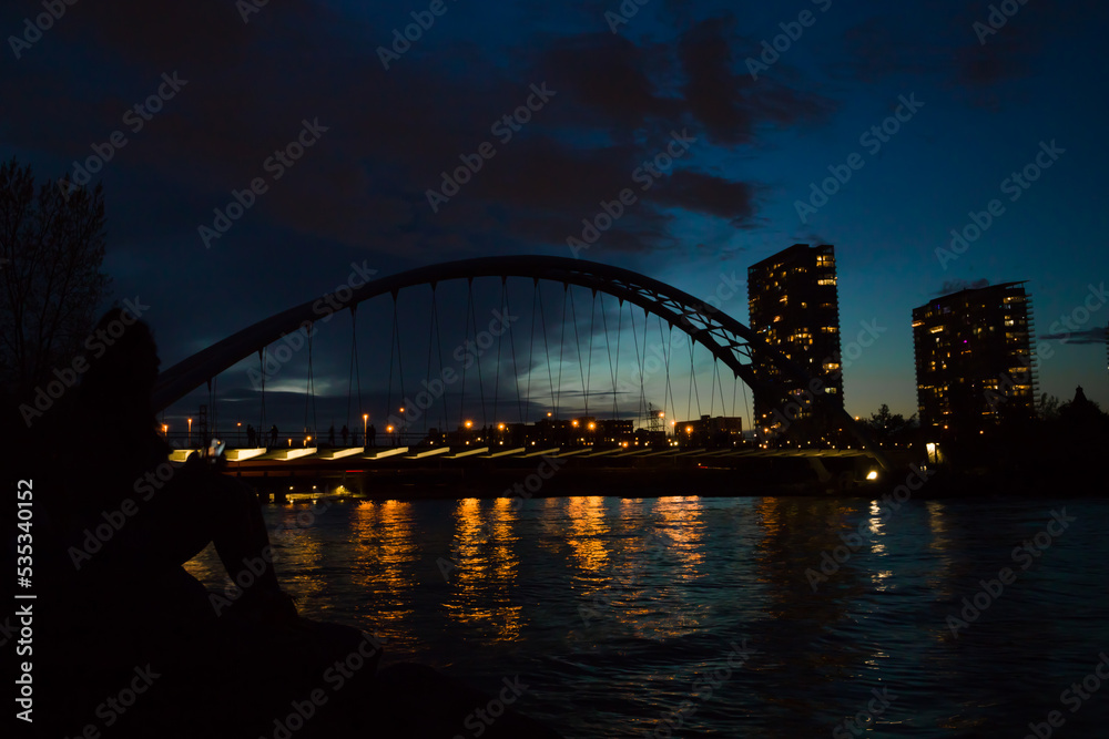 Obraz premium city harbor bridge at night. Illumination, cloudy sky and calm lake