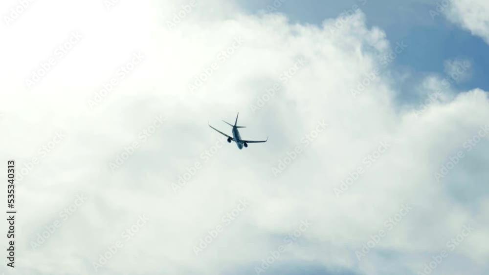 the plane is flying against a background of blue sky and sun the plane is flying against a background of blue sky and sun