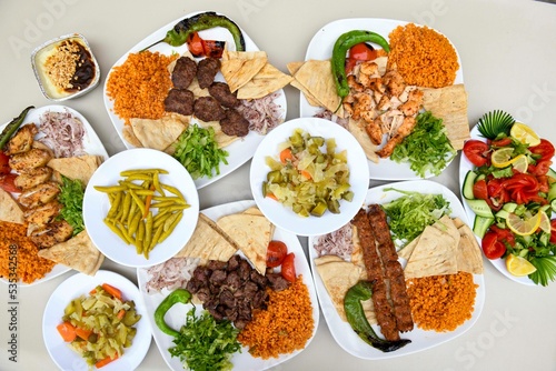Delicious meat kebab with fresh vegetable salad served with variety of Turkish dishes and appetizers. Top view of assorted Turkish food and meze  tasty and healthy Mediterranean cuisine.