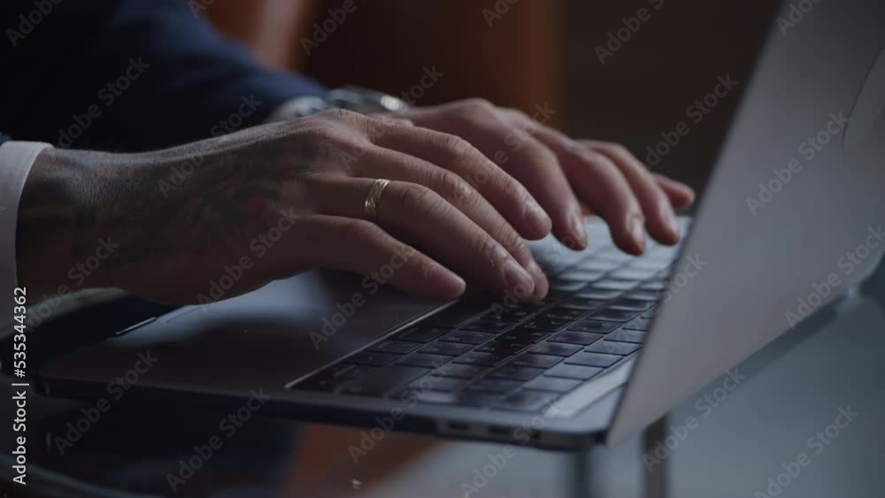 Tattoed businessman hands typing on a laptop keyboard close up Tattoed businessman hands typing on a laptop keyboard close up