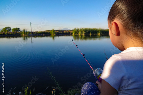 Niña pesca en el lago photo