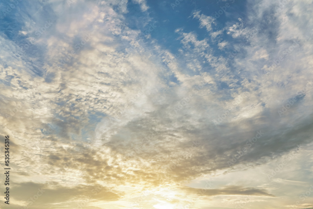 Fototapeta premium Morning blue orange sky, sun shining through clouds