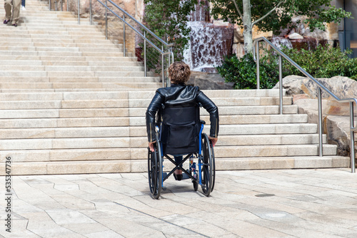 Foto Woman or man with impaired mobility using wheelchair blocked from trying to get