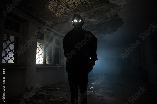 death with scythe standing in the dark hall of abandoned building. photo
