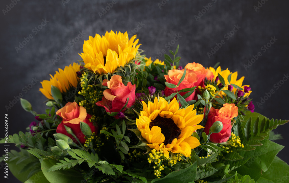 Close-up of a colorful fresh bouquet of roses and sunflowers, against a gray background Close-up of a colorful fresh bouquet of roses and sunflowers, against a gray background
