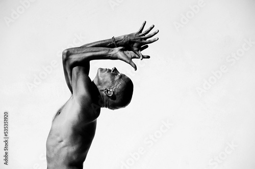 Man practicing perfect yoga photographed against a white background.  photo