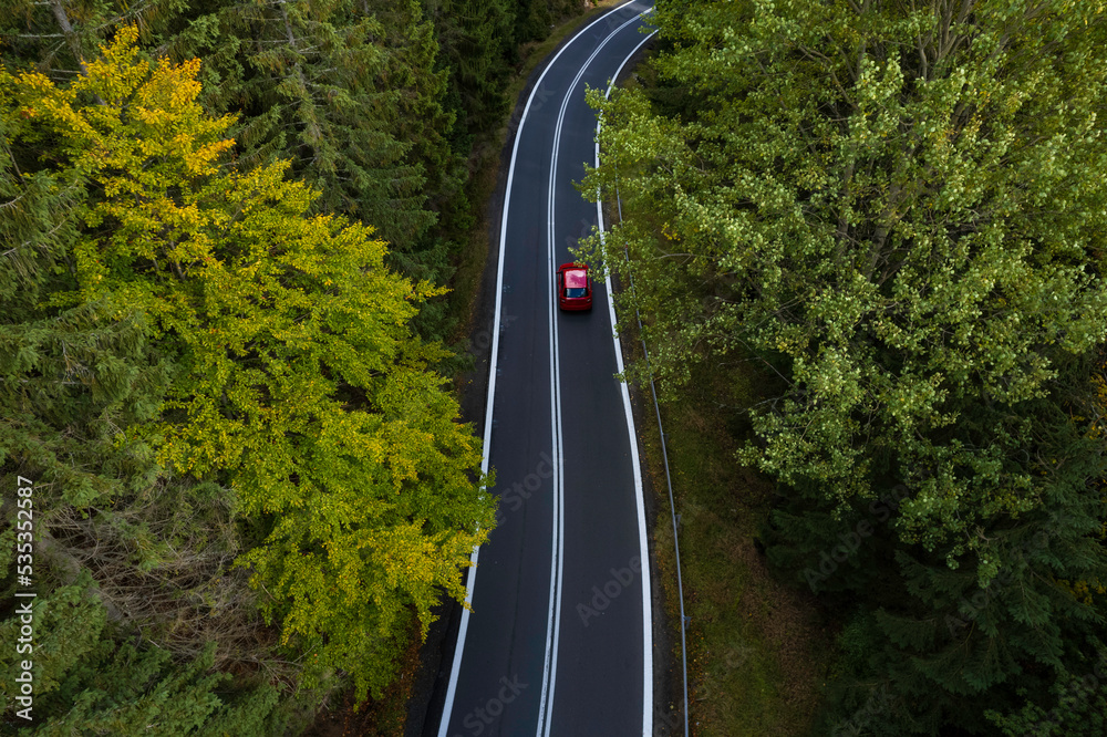 winding mountain road in a green forest (aerial view)