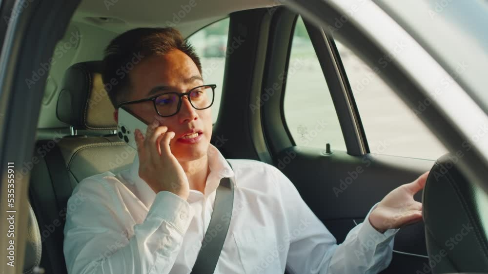 Young man driver close-up, calling, using phone. Car sharing concept, vehicle and transport. Asian happy guy driving, sitting in car. Traveling by automobile. Young man driver close-up, calling, using phone. Car sharing concept, vehicle and transport. Asian happy guy driving, sitting in car. Traveling by automobile.